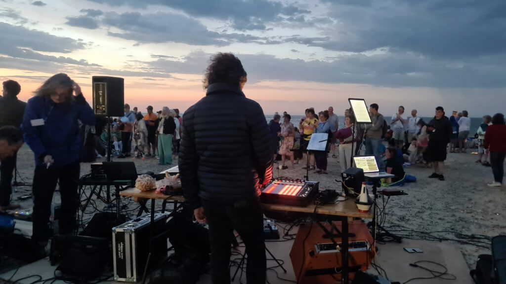 A beach at dawn in Suffolk, UK with musician Steve Pretty surrounded by electronics.